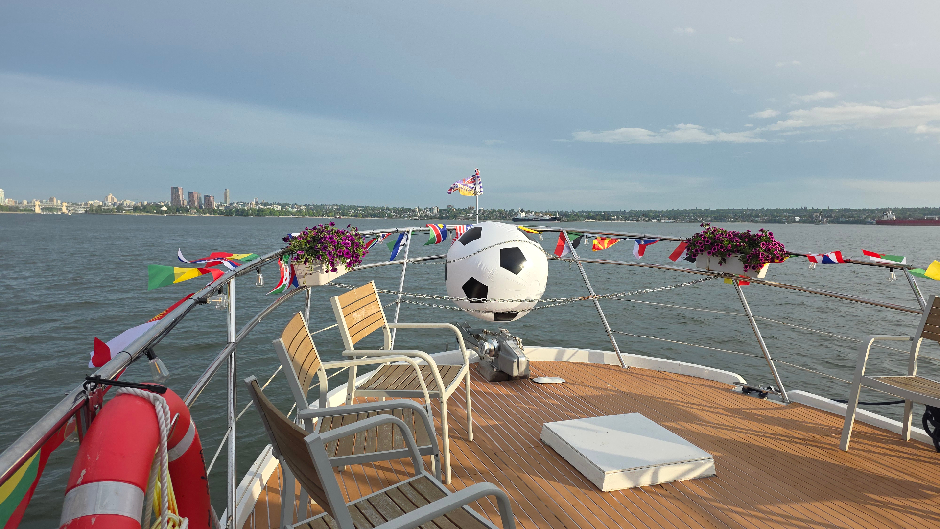 Shangri-La Joy bow deck with international flags and Vancouver skyline