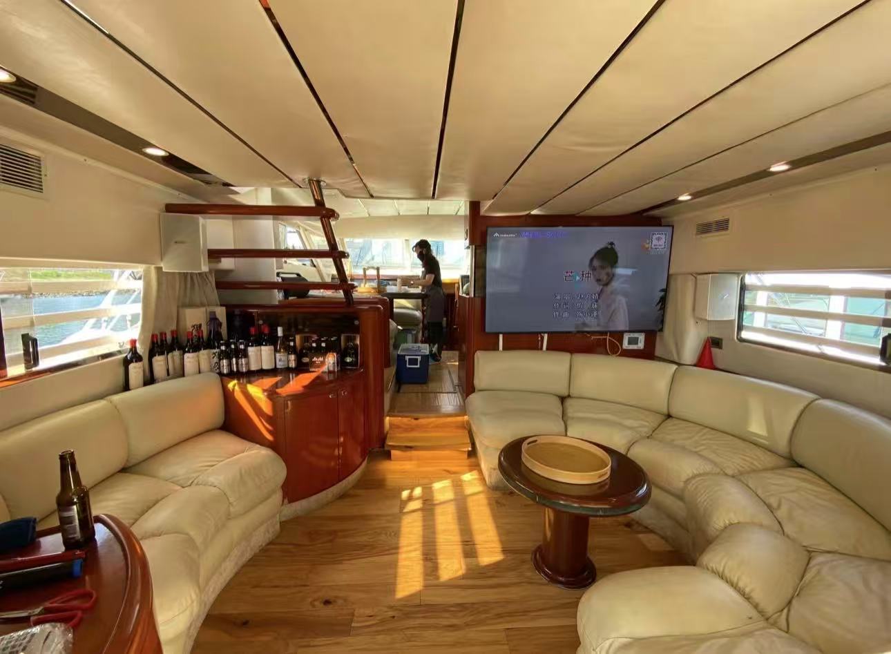 Summer Palace main salon with bar, TV and curved leather seating